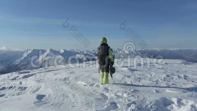 滑雪板带着滑雪板在雪山上走到山顶。 滑雪者在雪山峰上站起来，骑马